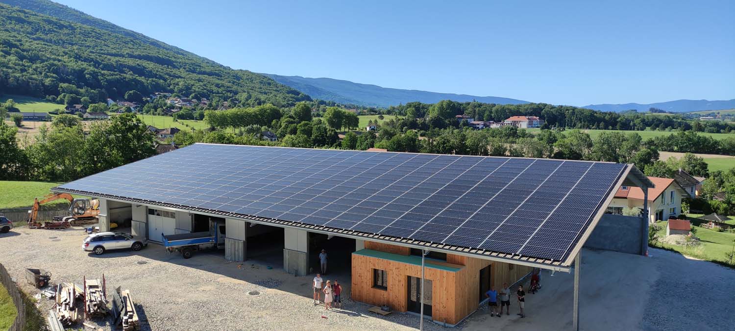Photo drone d'un hangar professionnel avec une toiture remplie de panneaux photovoltaïques