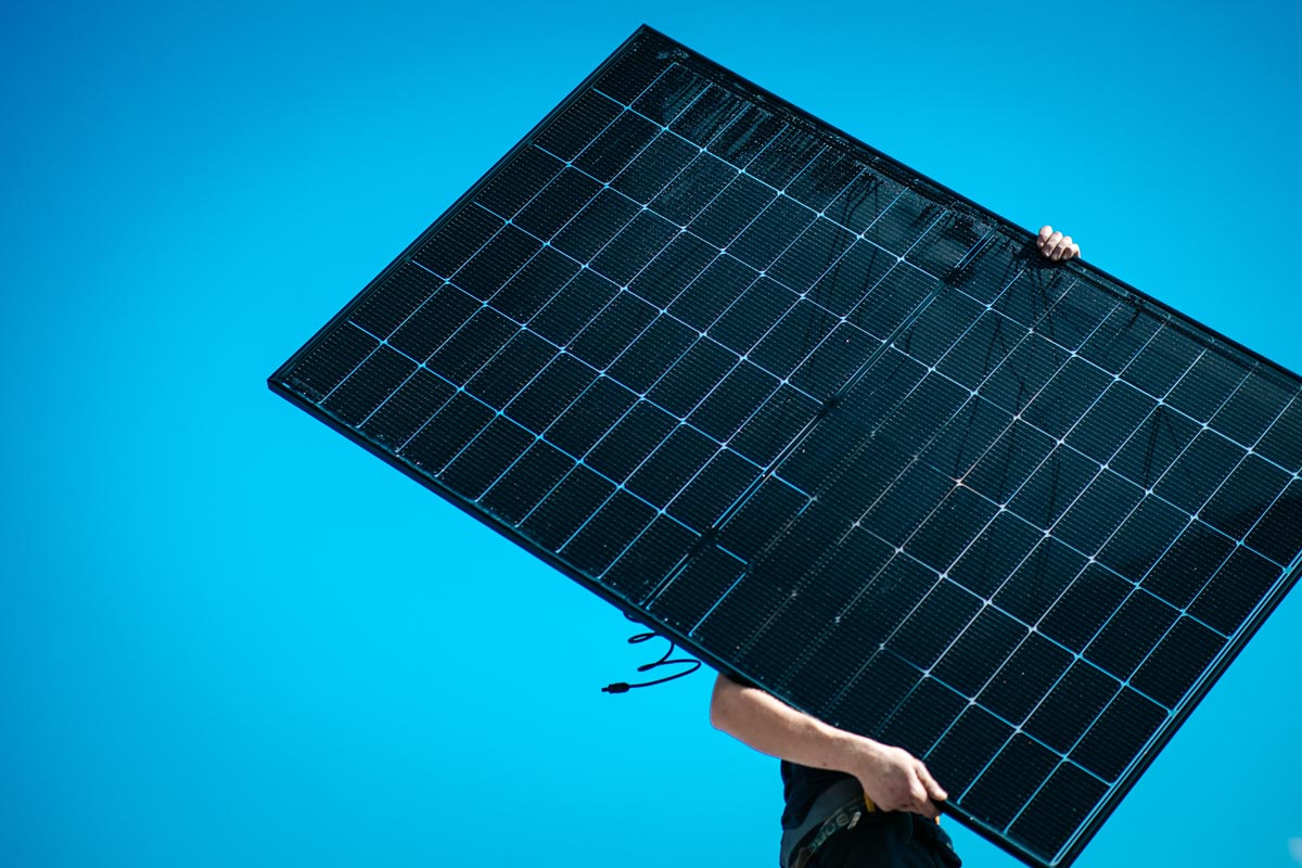 Photo d'une personne entrain de porter un panneau solaire